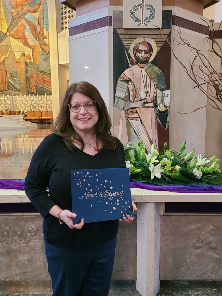 alumna posing with award